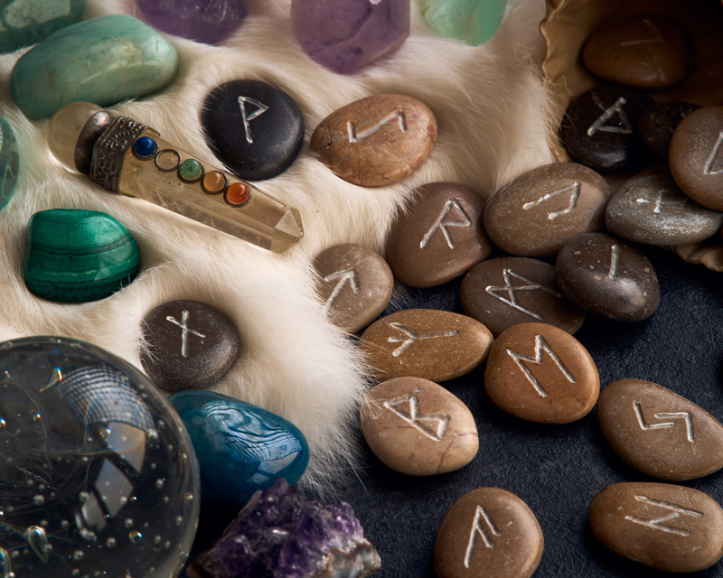 Runes are small stones with symbols etched and/or painted on them. They are mixed among colorful gemstones.