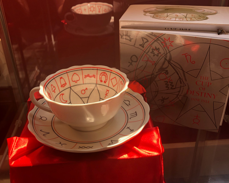 A tea cup with red painted symbols inside the cup and on the saucer made especially for tea leaf readings.